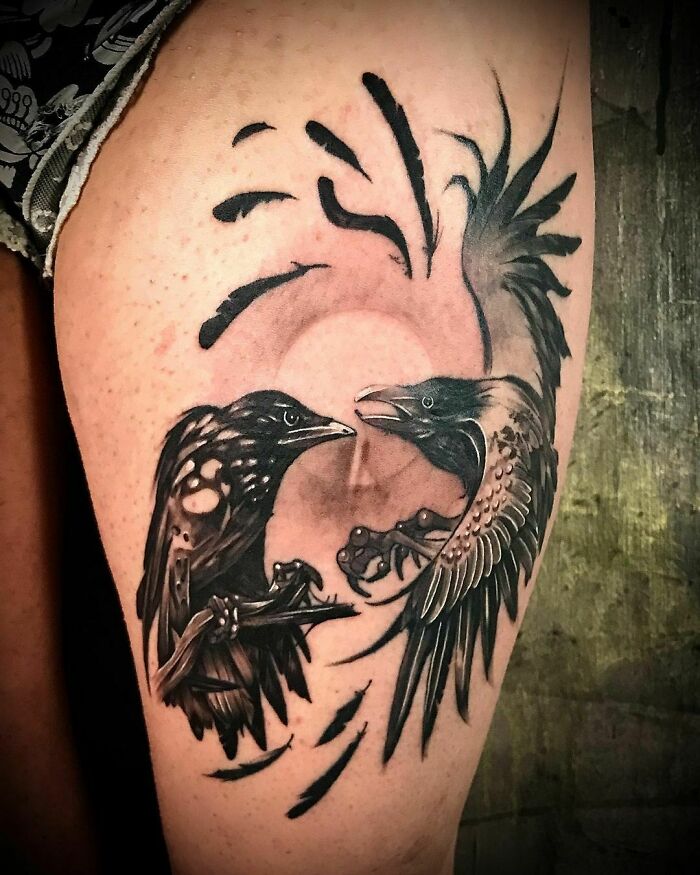 Animal tattoo of two intricately detailed birds facing each other on a person's leg.