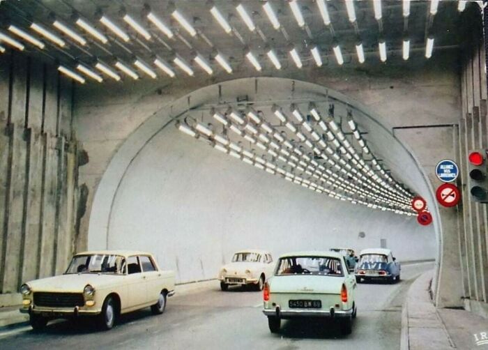 Cars driving through a brightly lit tunnel, showcasing interesting urban lighting gadgets from around the world.