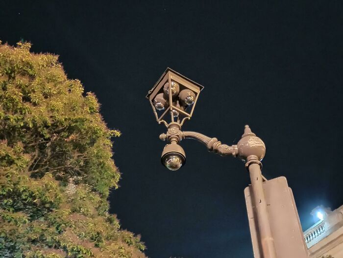 Innovative city streetlight gadget with surveillance cameras at night.