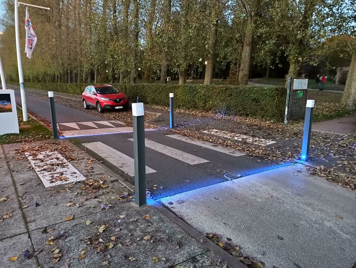 Innovative pedestrian crossing with blue LED lights, showcasing interesting gadgets from cities worldwide.