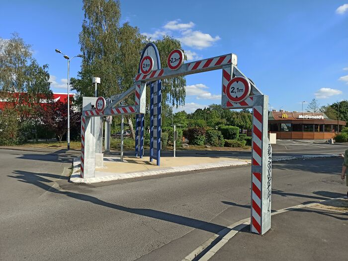 Traffic height restriction gadget in front of a McDonald's, showcasing urban innovation for worldwide implementation.