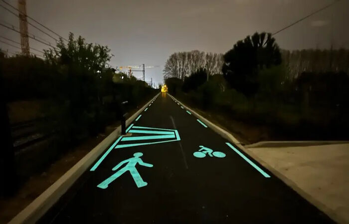 Glowing road with pedestrian and bicycle symbols, showcasing interesting urban gadgets worldwide.