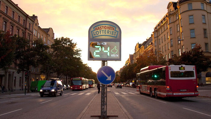 Speed lottery gadget in a city street, displaying speed in kilometers per hour at sunset.