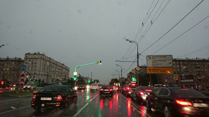 Rainy city street with traffic lights and cars, showcasing interesting urban gadget implementation.