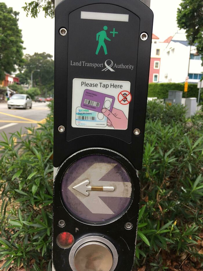 Crosswalk button from city, featuring tap sign, promoting pedestrian-friendly gadgets worldwide.