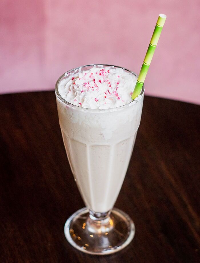 Photo of white milkshake with green straw