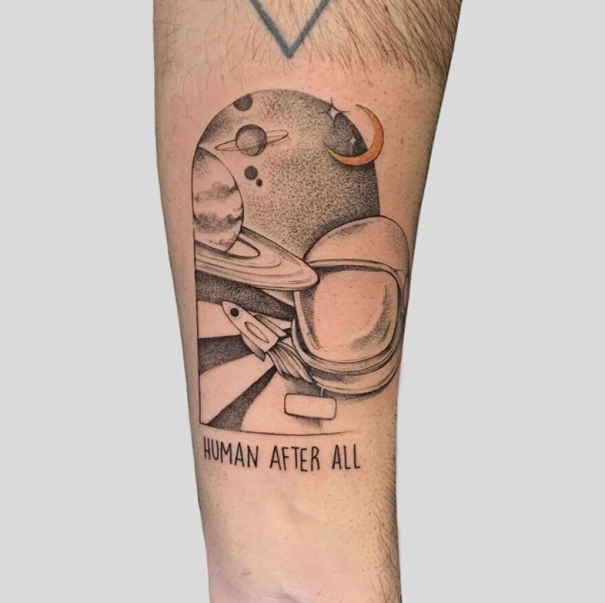 Space tattoo featuring planets, a rocket, and an astronaut helmet with the text "Human After All."