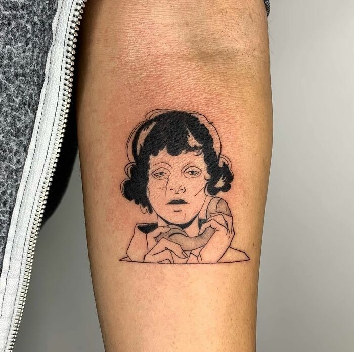 Illustration-style tattoo of a woman's face and hands on an arm.