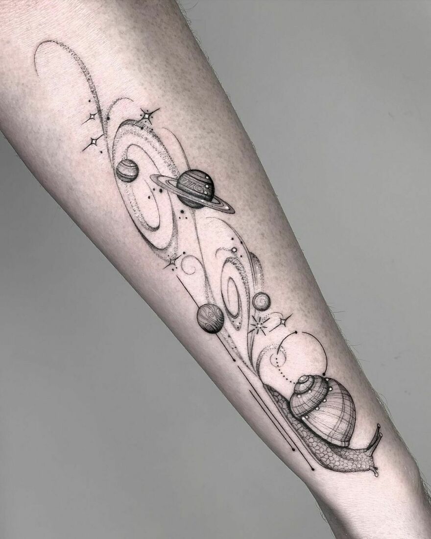 Intricate space tattoo on forearm featuring planets, stars, and cosmic swirls, showcasing outer space cool designs.