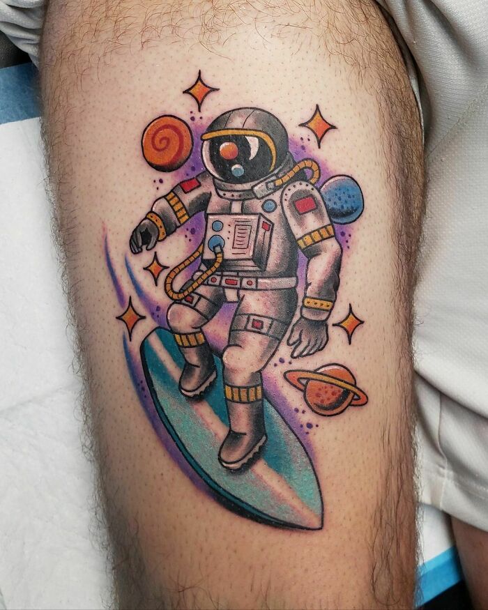 Astronaut space tattoo with colorful planets, stars, and cosmic elements for astrology fans.