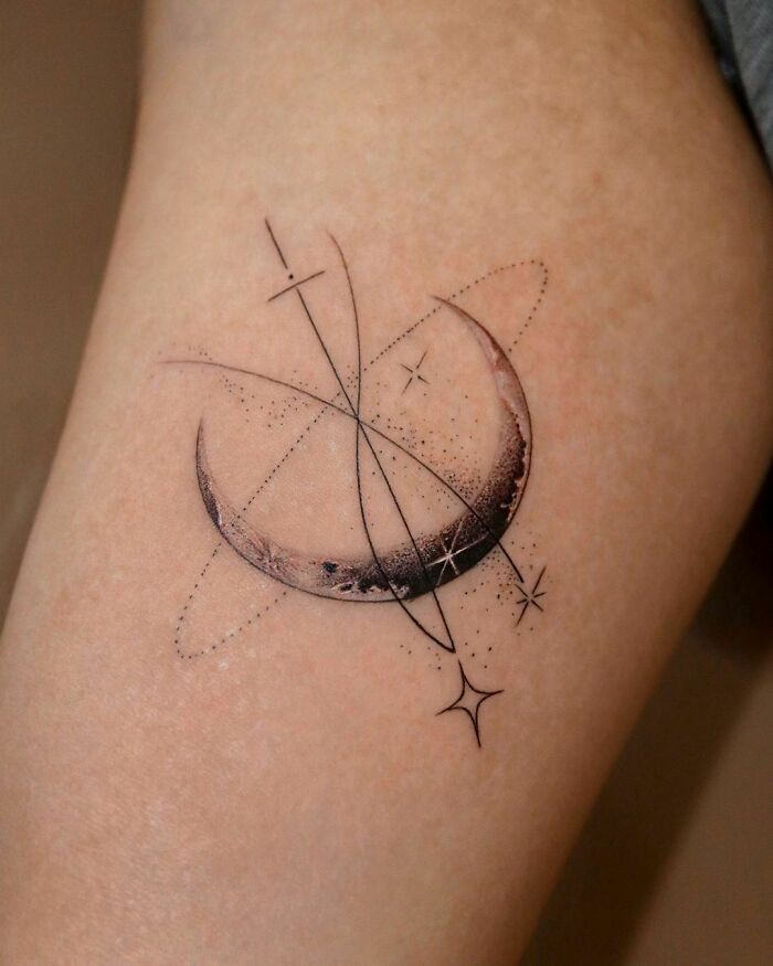 Space tattoo featuring a crescent moon with geometric star designs on skin.