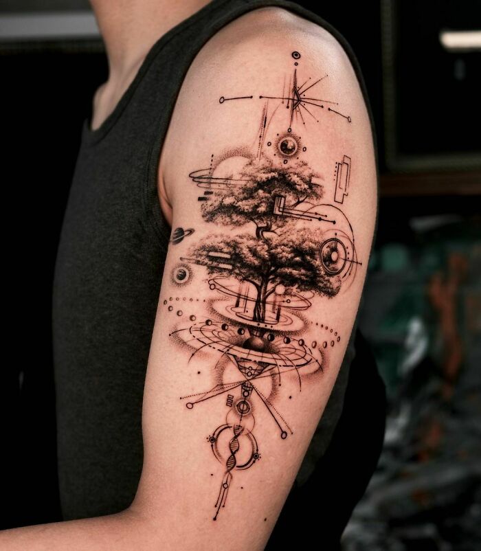 Arm with intricate space tattoo featuring cosmic elements and a tree, blending nature with the universe.
