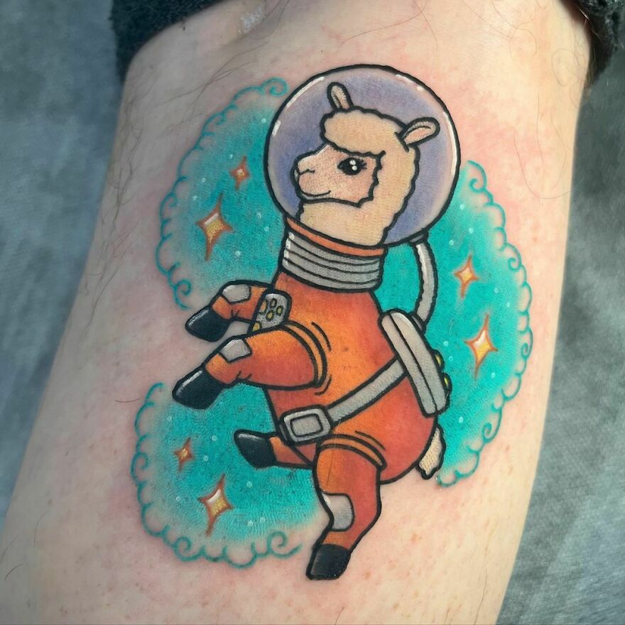 Tattoo of a cartoon llama in an astronaut suit, representing space tattoos with vibrant colors and cosmic elements.