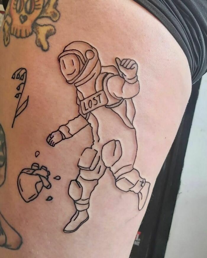 Line art tattoo of an astronaut with "Lost" on helmet, symbolic of space and astrology themes.