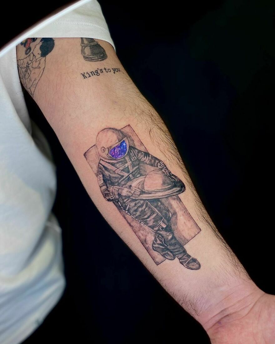 Astronaut tattoo on arm, showcasing outer space cool design details.