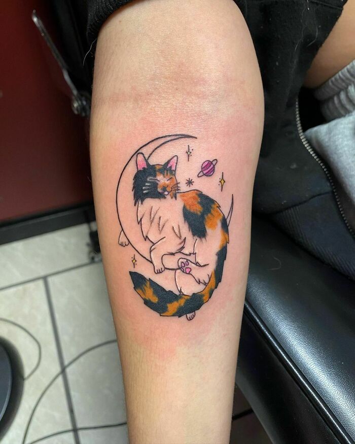 Cat on crescent moon tattoo with planets and stars, perfect for astrology fans.