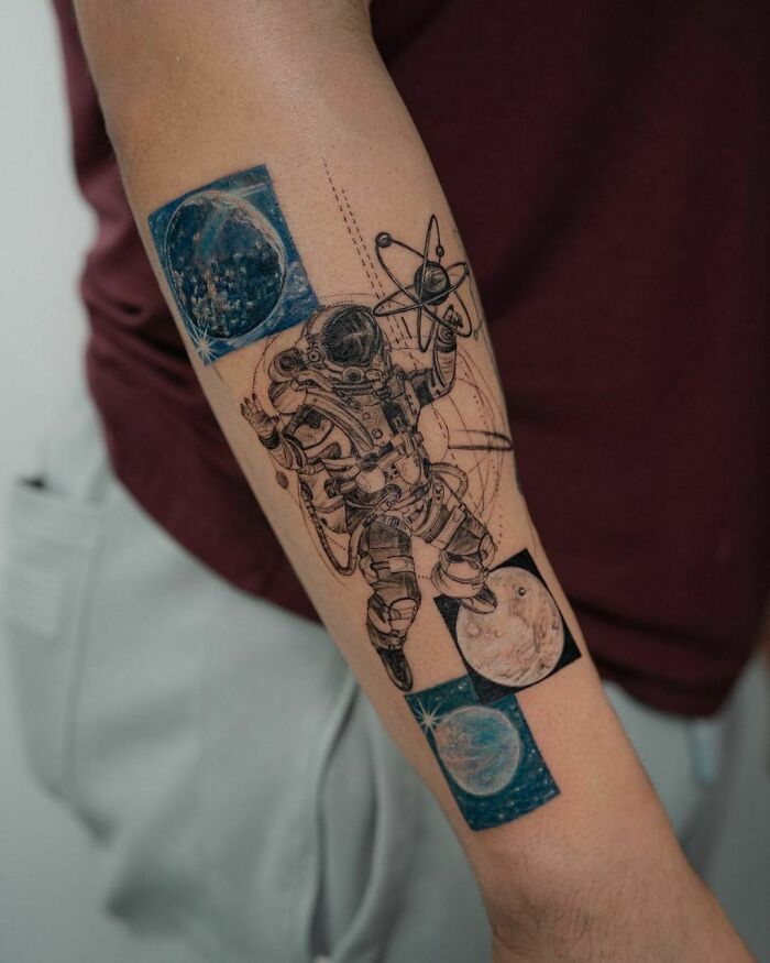 Astronaut tattoo with planets and stars on forearm, perfect for astrology fans.