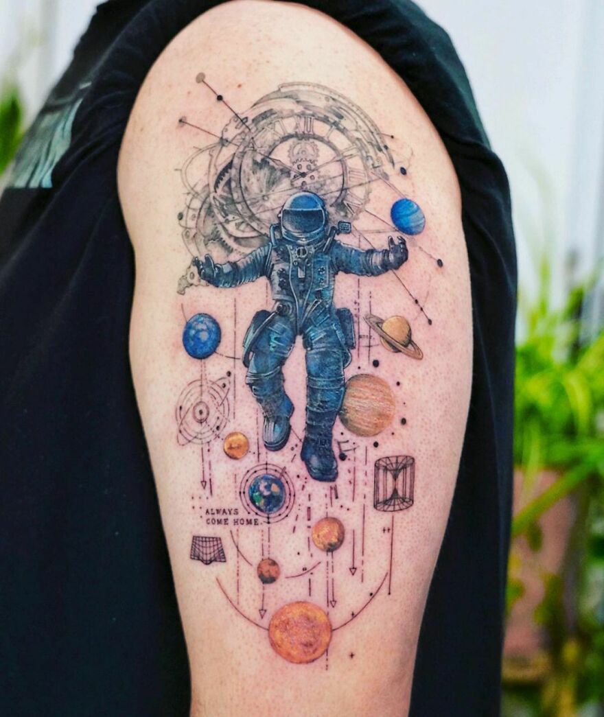 Astronaut tattoo with planets and celestial designs, showcasing outer space cool on an upper arm.