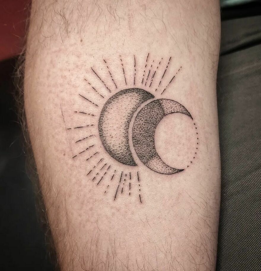 Outer space tattoo of overlapping crescent moons and radiating lines on an arm.