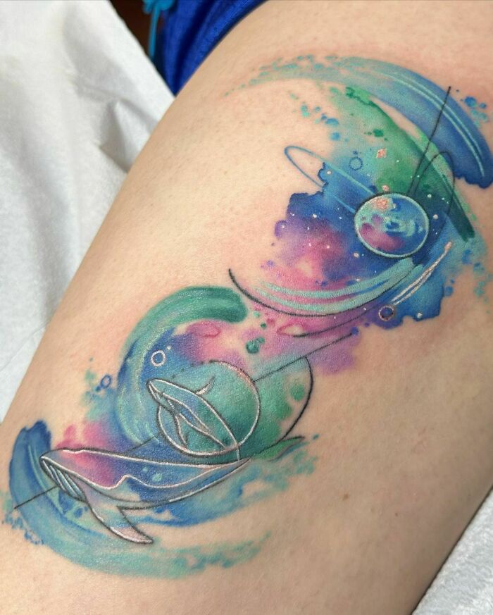Abstract colorful space tattoo with planets and swirling cosmic elements.