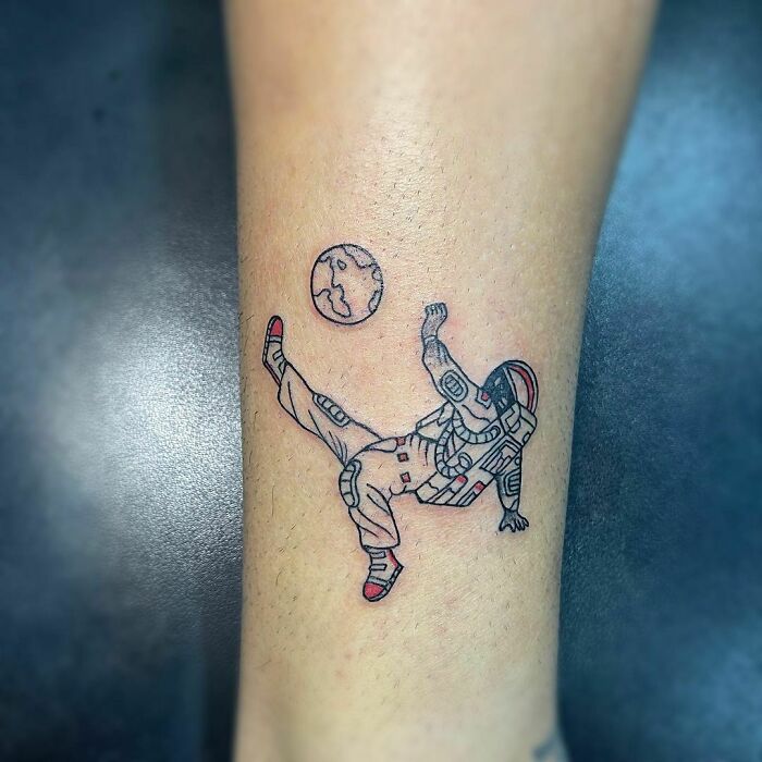 Astronaut tattoo on arm, depicting a space theme with Earth in the background. Perfect for astrology fans.