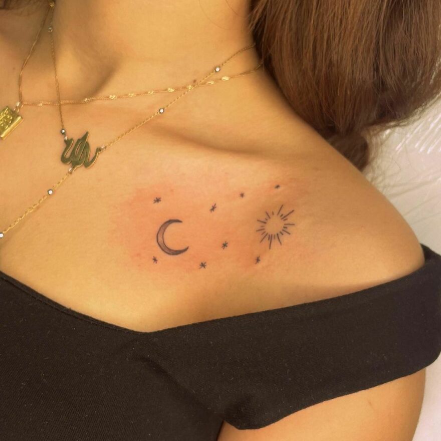Tattoo of a crescent moon, stars, and sun on a shoulder, exemplifying an outer space theme.