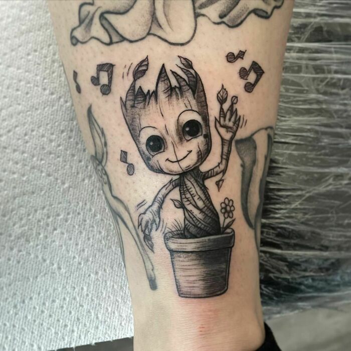 Cute Groot tattoo design featuring a dancing potted plant with musical notes, capturing Marvel superhero charm.