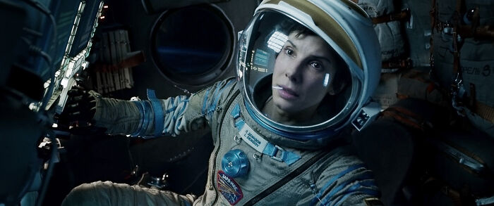 Actress in astronaut suit inside a spacecraft, representing one of the highest-paid actors in film history.