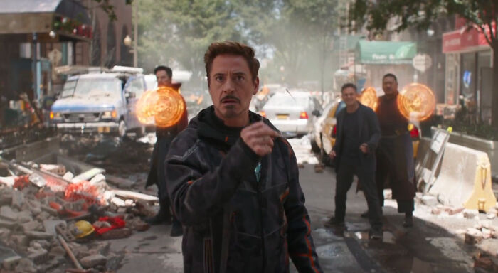 Actor Robert Downey Jr. in an action scene with magical effects, representing highest-paid actors in a dramatic urban setting.