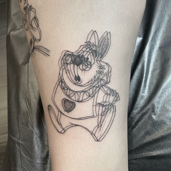 Tattoo of a character with a heart symbol, featuring a 'moving' effect on a person's arm, giving a dizzying impression.