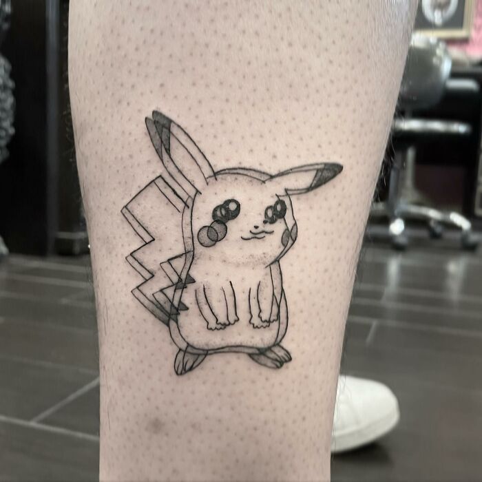 Tattoo of a stylized Pikachu on a leg, showcasing intricate design that might feel dizzying at first glance.