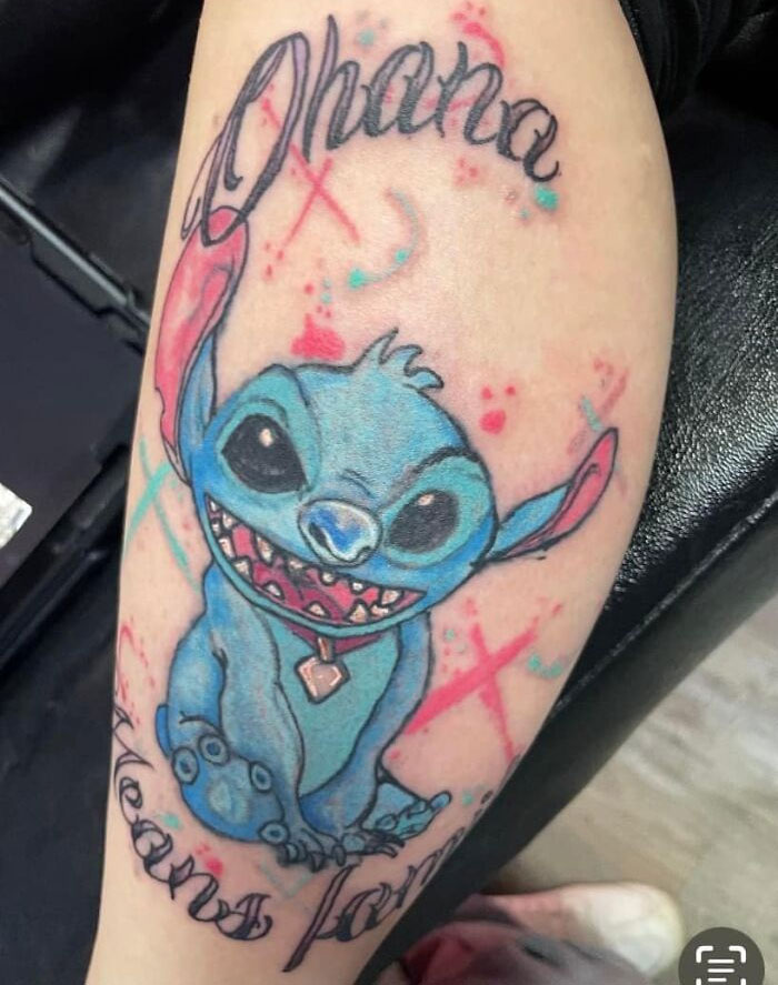 Bad tattoo of a blue cartoon character with the word "Ohana" on a person's arm.