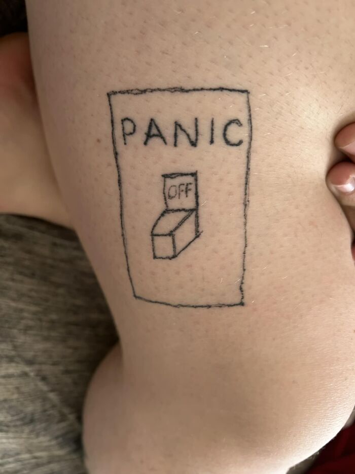 Poorly drawn tattoo of a "panic" switch on skin, part of hilariously bad tattoos collection.