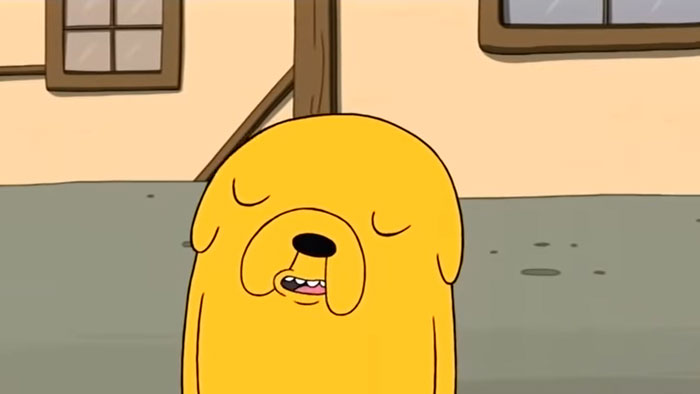 Cartoon character with closed eyes in a relaxed pose in front of a building background.