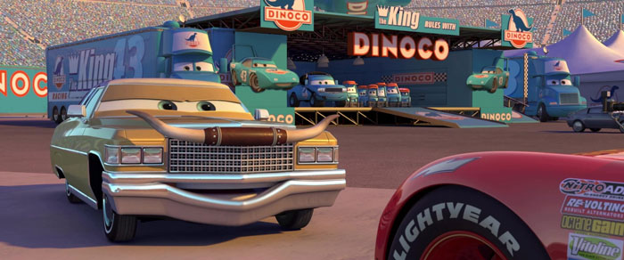 Animated cars scene from a popular cartoon, featuring characters gathered near a Dinoco truck in a racing arena.