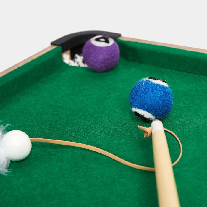 Person playing with a Wooden stick and woolen pool balls Person playing with a Wooden stick and woolen pool balls