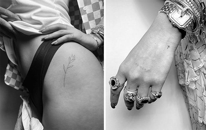 Celebrity tattoos featuring a minimalist flower on a hip and small text on a hand adorned with rings and bracelets.