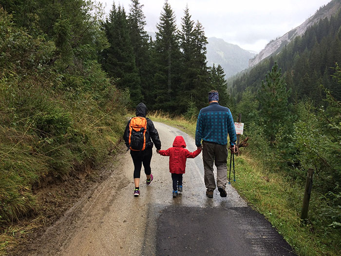 Man, woman, and child walking together along dirt road