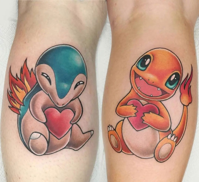 Matching tattoos of two animated creatures holding hearts, ideal for couples or friends.