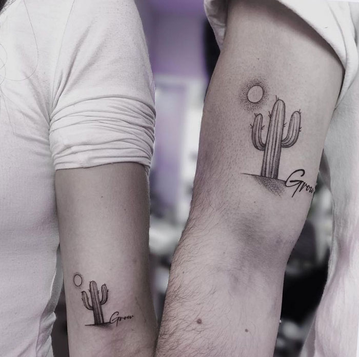 Matching tattoos with cactus design on arms signifying growth.