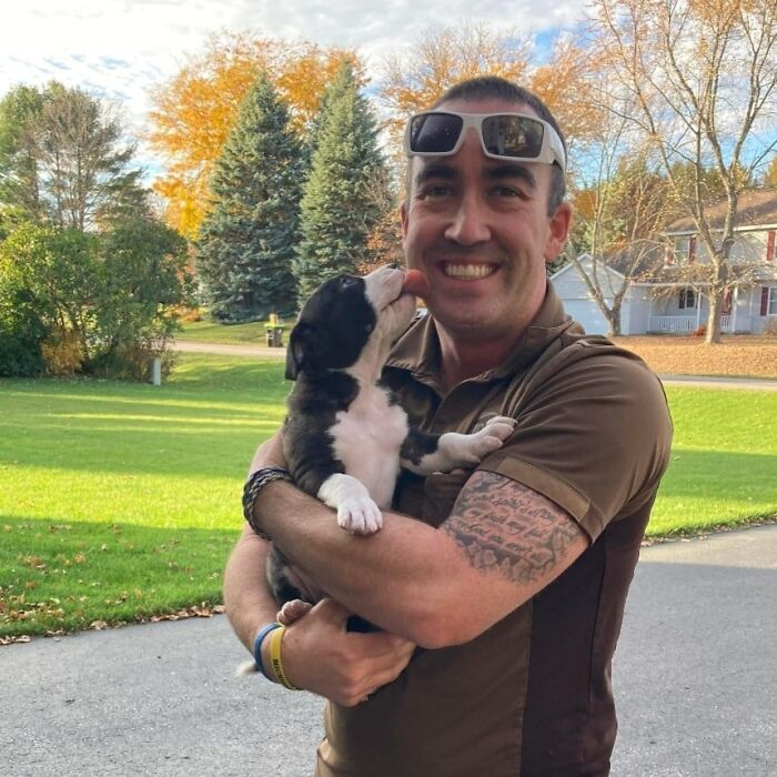 Noah Getting Puppy Kisses From A Foster Puppy On His Route In Traverse City, Michigan