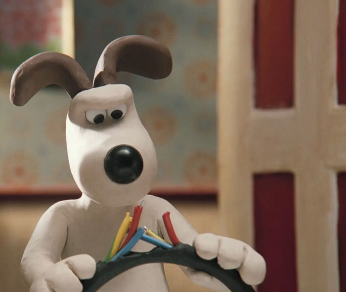 Cartoon dog with expressive eyes examining colorful wires inside a house setting.
