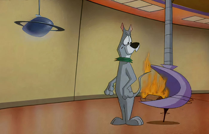 A famous cartoon dog in a futuristic room looks at a fire.