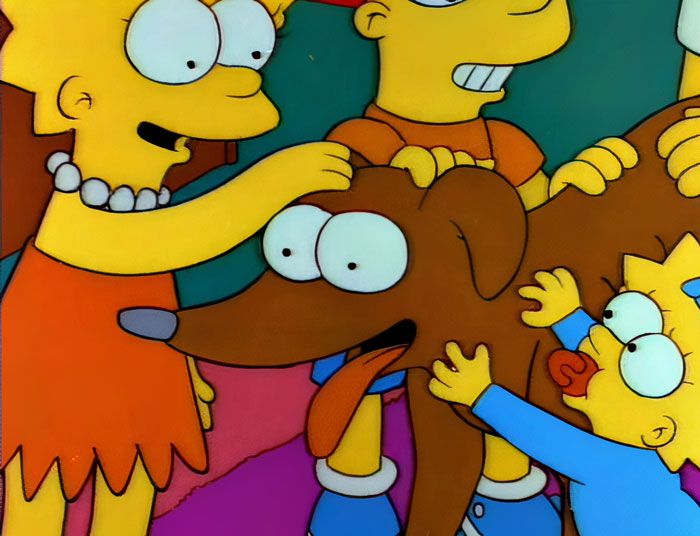 Cartoon dog being petted by three animated characters in a colorful scene.