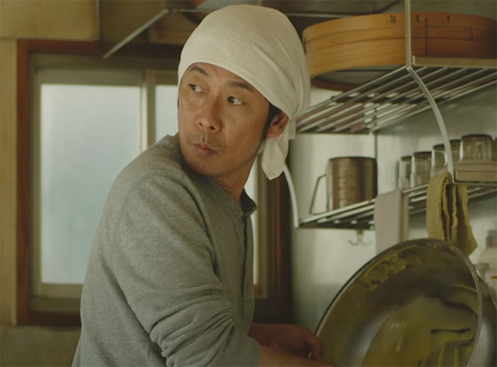 Sweet Bean character cooking wearing gray shirt