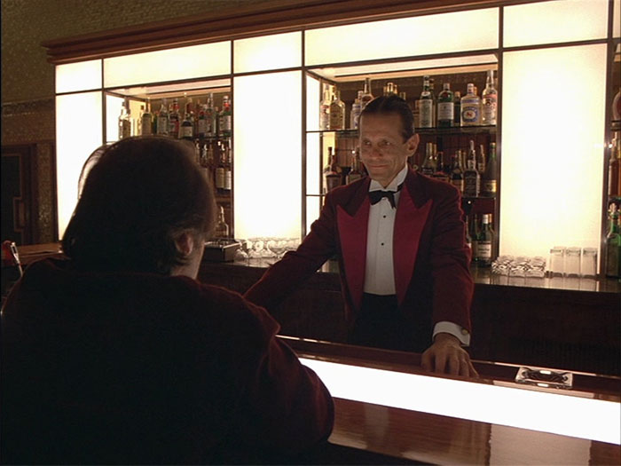 Joe Turkel standing in a bar 