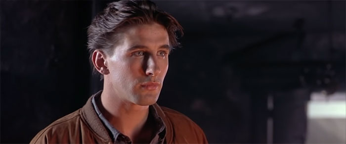 Billy Baldwin looking at someone in the dark 