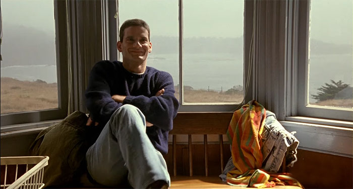 Campbell Scott sitting happy with his hands crossed 