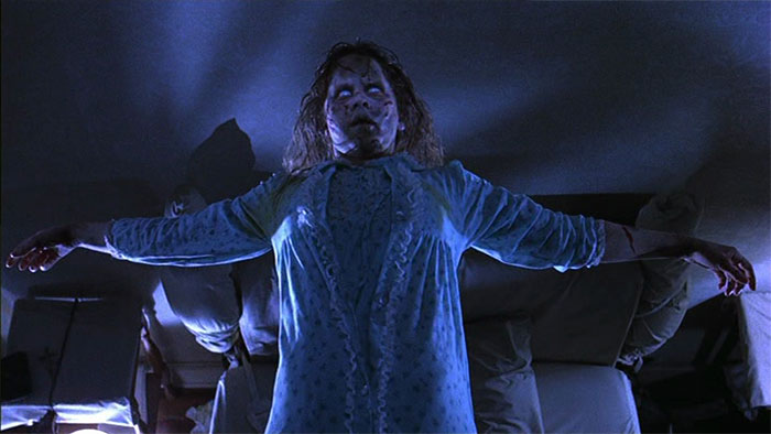 Woman possessed by a demon floating above the bed 