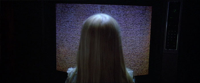 Little girl standing in front of tv